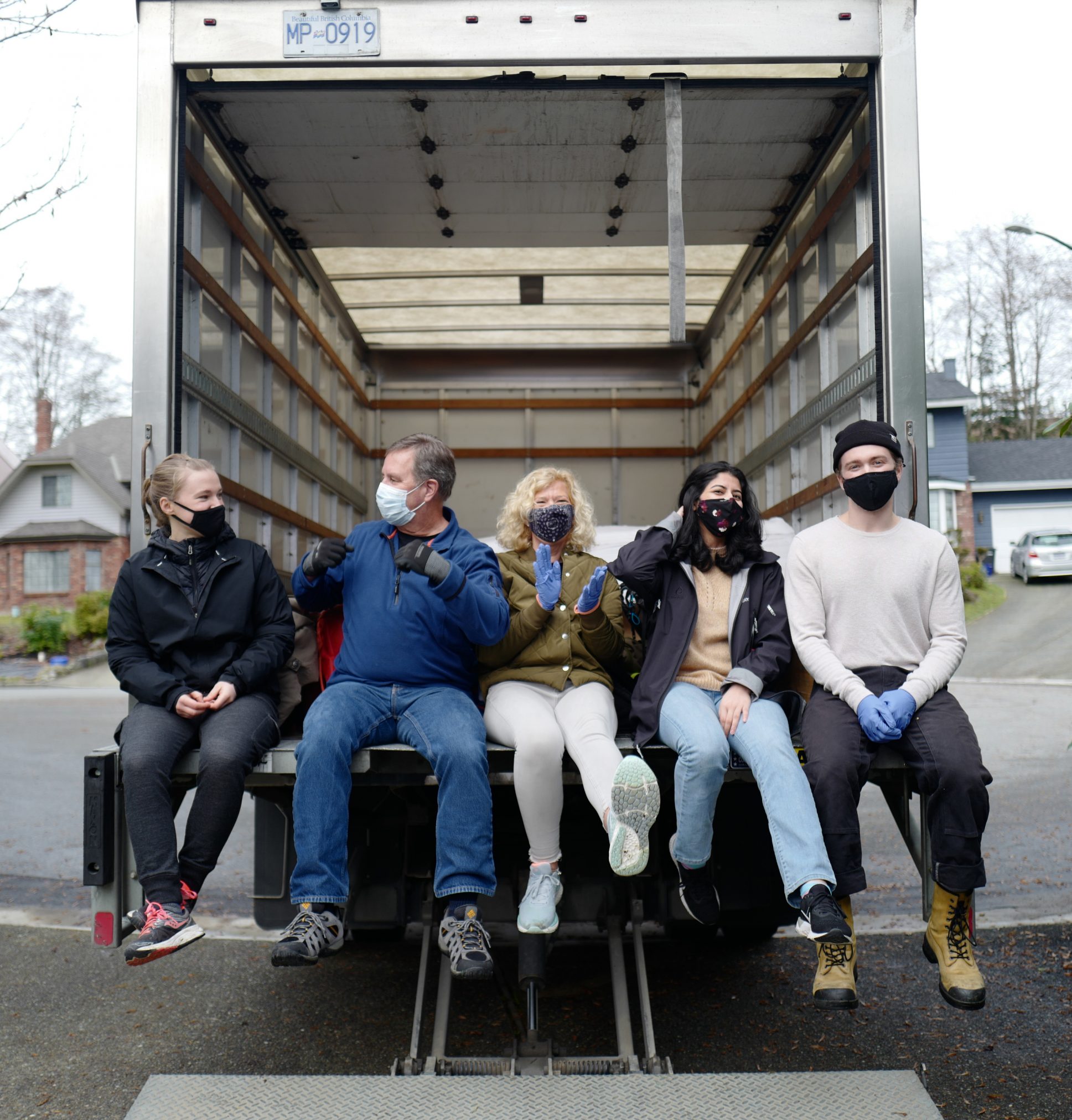 Volunteers sitting on back of truck