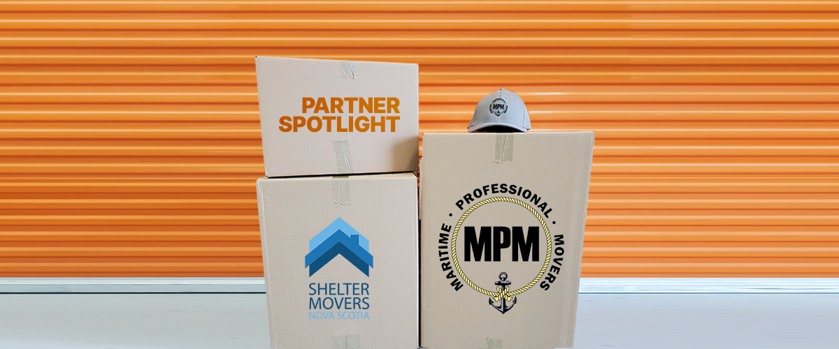 3 moving boxes in front of a storage unit feature the text "Partner Spotlight, Shelter Movers Nova Scotia, Maritime Professional Movers"